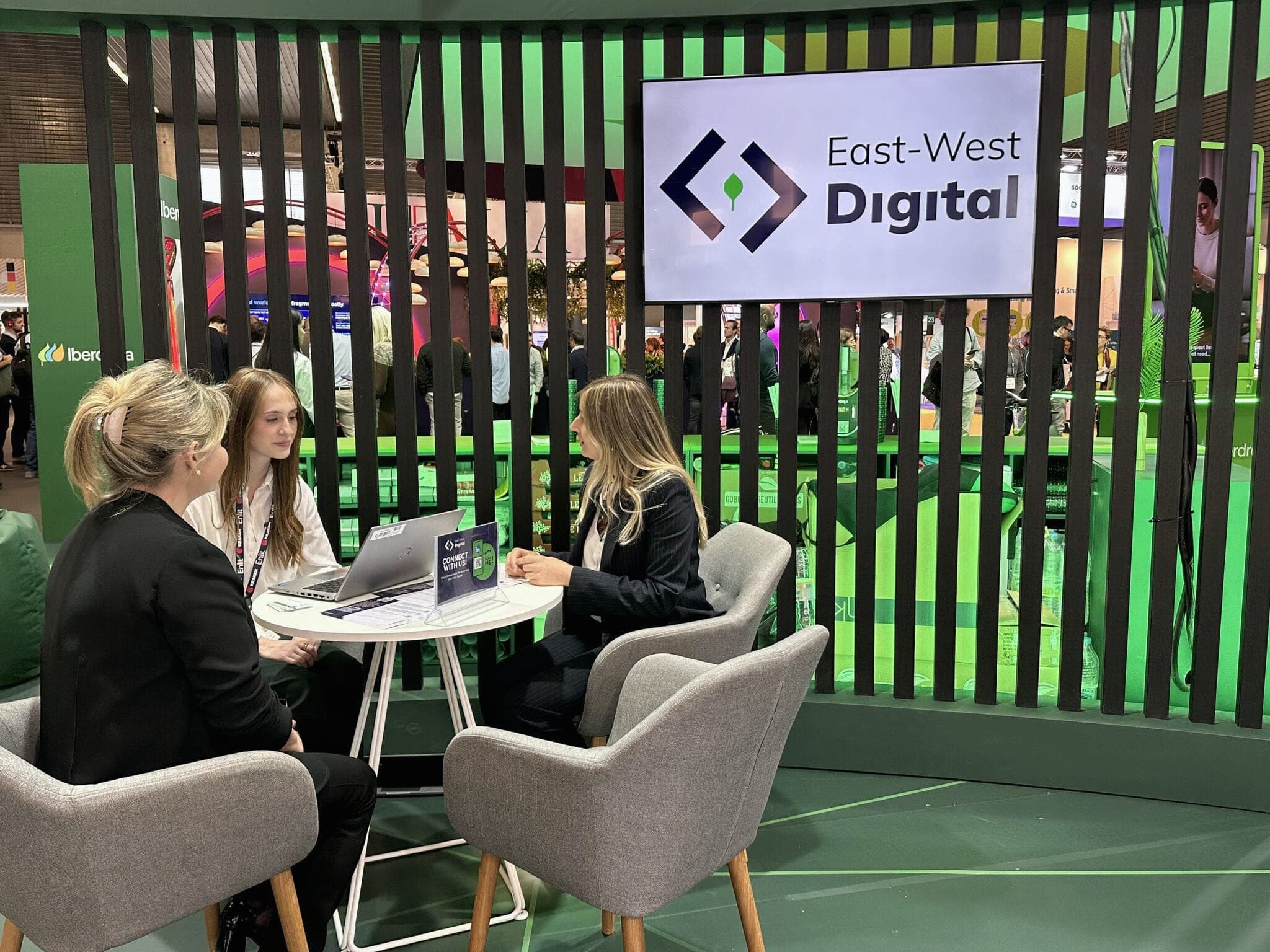 Visitors in conversation with the EWD team at the East-West Digital stand